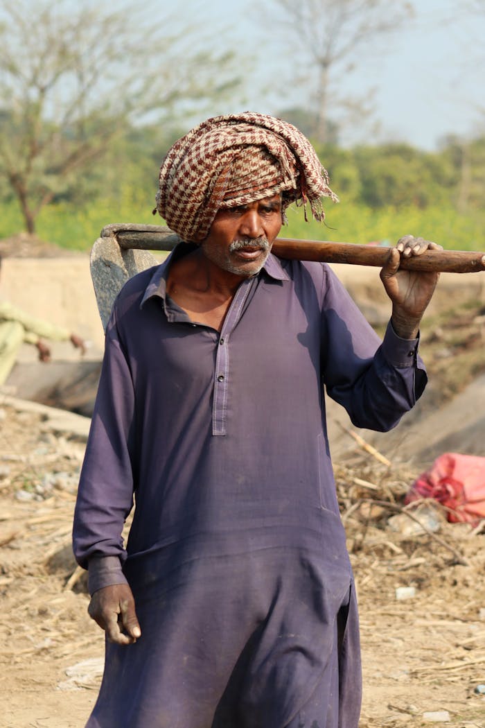 Crafting Captivating Headlines: Your awesome post title goes here South Asian farmer in traditional attire carrying a tool in Lahore, Pakistan.