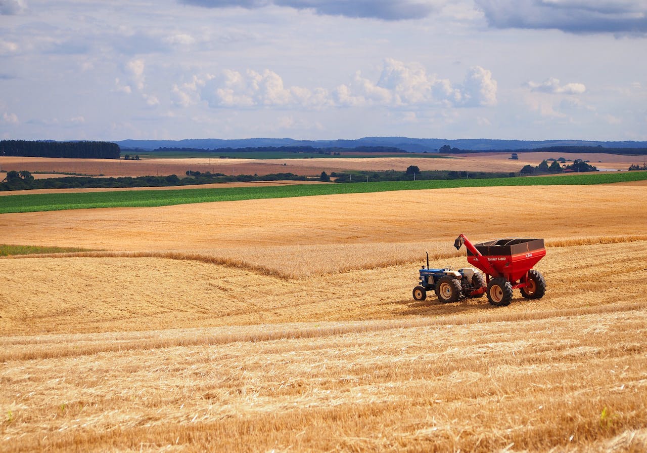 Contact A tractor harvesting crops in a vast agricultural field in Entre Rios, Brazil.